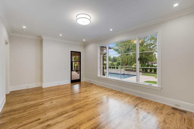 unfurnished room featuring crown molding, light hardwood / wood-style floors, and plenty of natural light