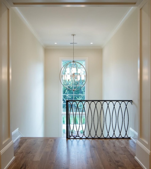 hallway with a chandelier, crown molding, and hardwood / wood-style floors