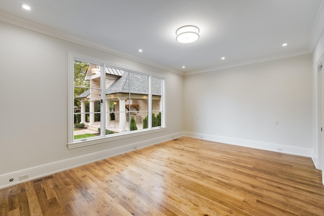 empty room featuring light hardwood / wood-style flooring and crown molding