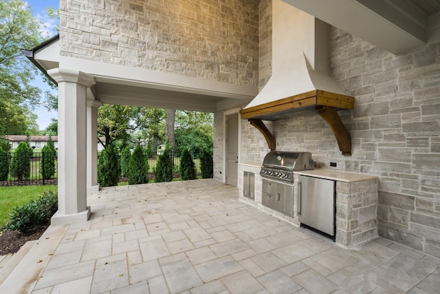 view of patio / terrace featuring an outdoor kitchen and a grill