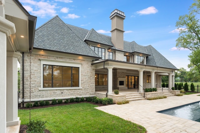 back of house featuring a fenced in pool, a yard, and a patio