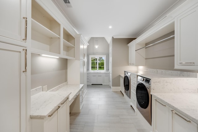 washroom with independent washer and dryer, ornamental molding, and cabinets