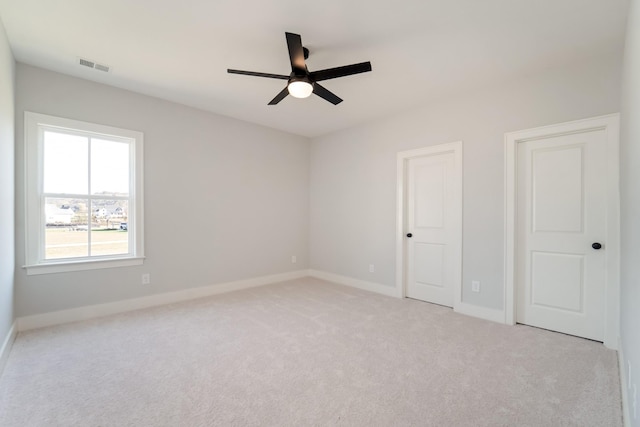 spare room with ceiling fan and light colored carpet