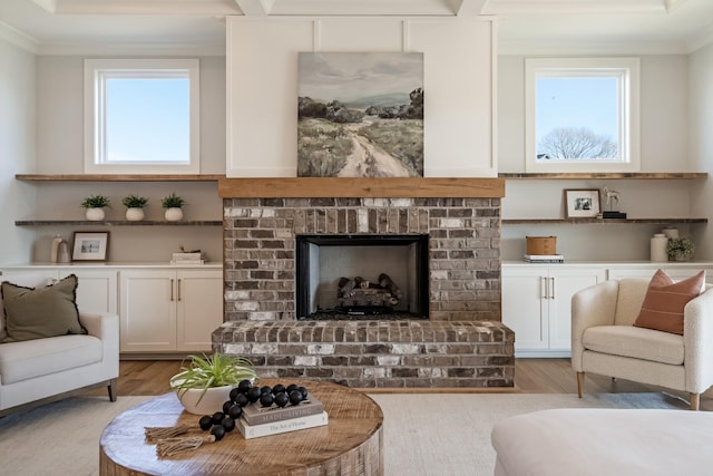 living room with a fireplace, crown molding, and light hardwood / wood-style floors