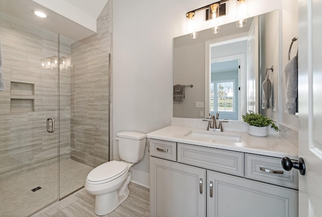 bathroom with toilet, vanity, and an enclosed shower