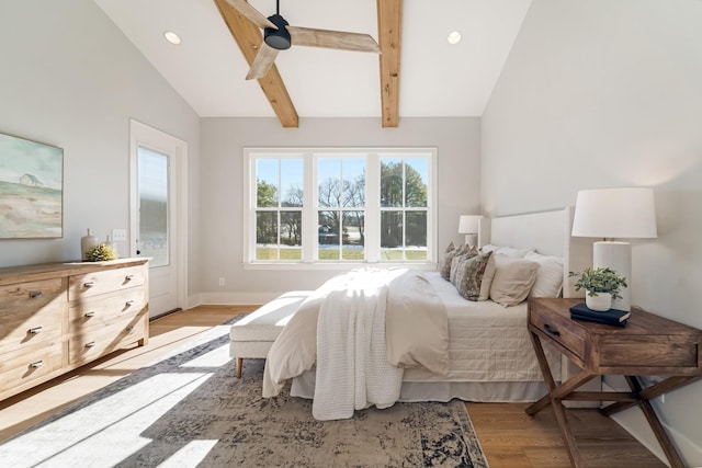 bedroom featuring ceiling fan, vaulted ceiling with beams, and light wood-type flooring