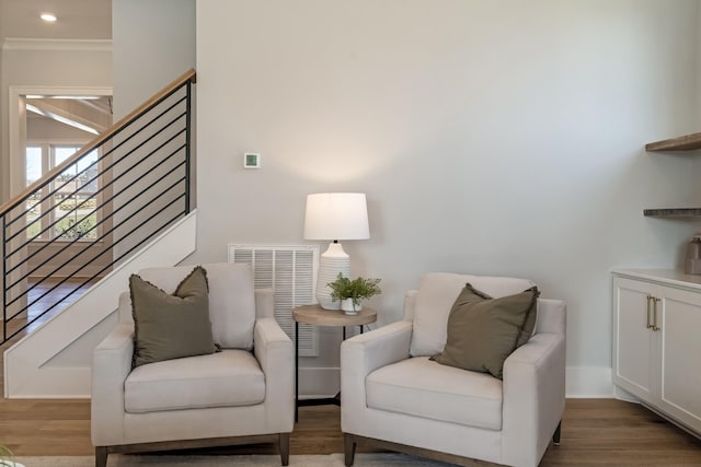 sitting room with wood-type flooring and ornamental molding