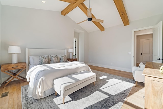 bedroom with light wood-type flooring, ceiling fan, and vaulted ceiling with beams