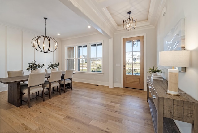 foyer entrance with an inviting chandelier, crown molding, and light hardwood / wood-style floors