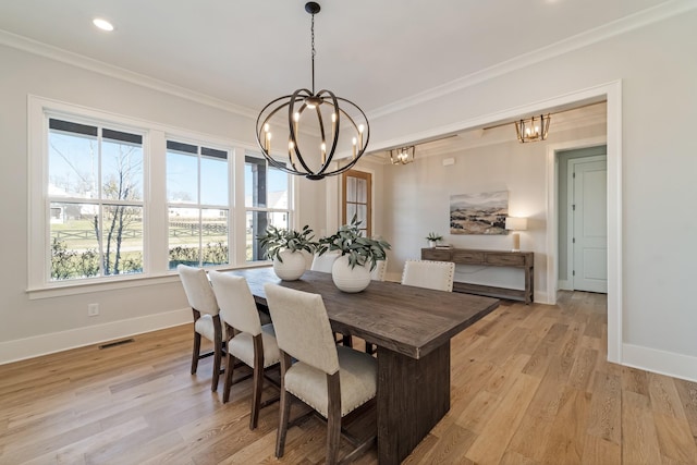 dining area with crown molding, a chandelier, and light hardwood / wood-style floors