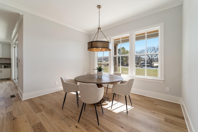 dining space featuring crown molding and light hardwood / wood-style floors