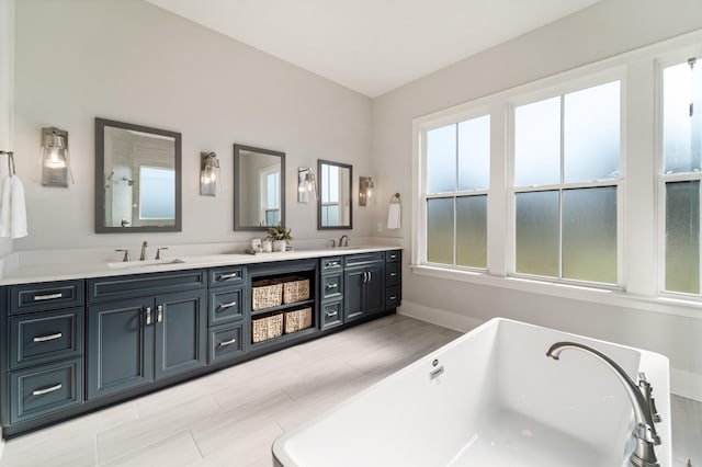 bathroom with a tub to relax in and vanity