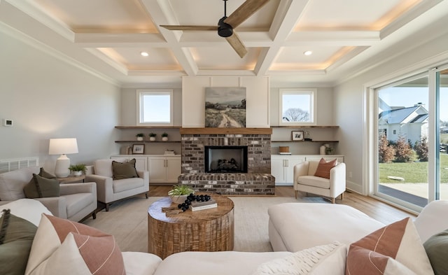 living room with light hardwood / wood-style floors, ceiling fan, a brick fireplace, beam ceiling, and coffered ceiling