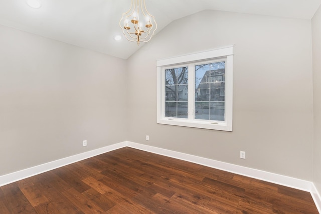 spare room featuring hardwood / wood-style flooring, lofted ceiling, and a notable chandelier