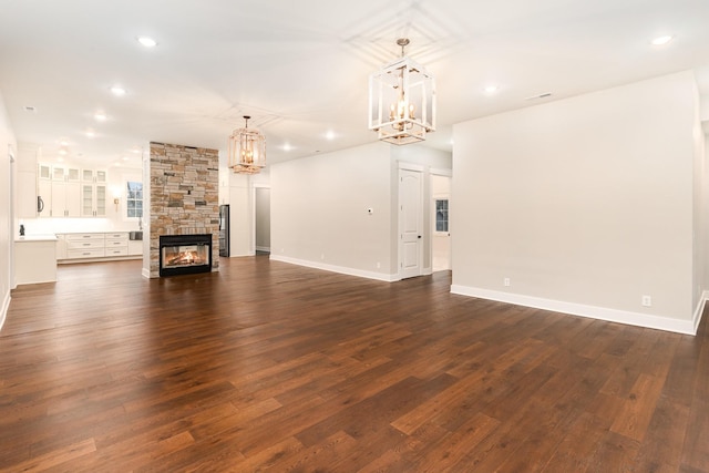 unfurnished living room with dark hardwood / wood-style floors and a stone fireplace