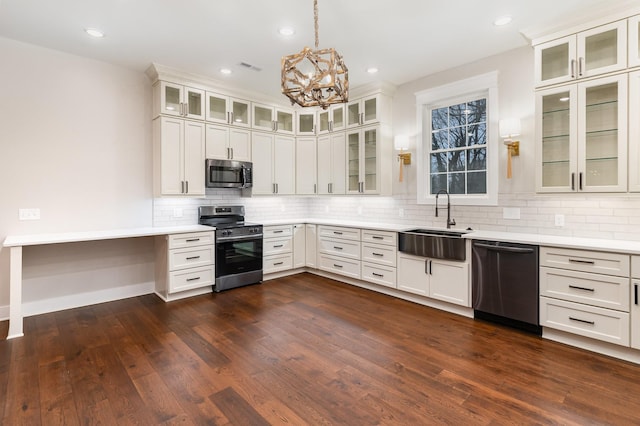 kitchen with appliances with stainless steel finishes, tasteful backsplash, pendant lighting, white cabinets, and sink