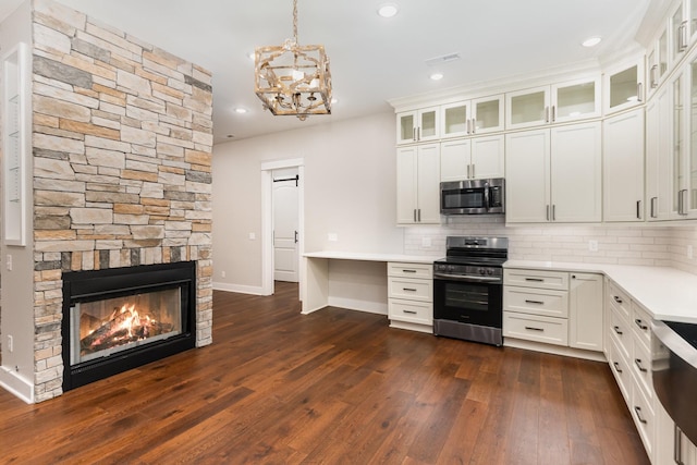 kitchen featuring white cabinetry, pendant lighting, appliances with stainless steel finishes, and decorative backsplash