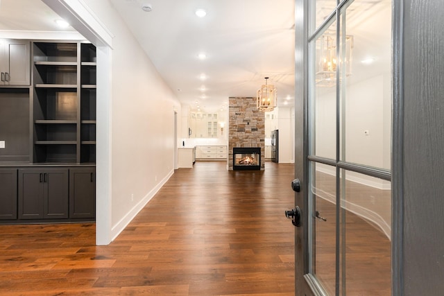 hall with dark hardwood / wood-style floors and a chandelier