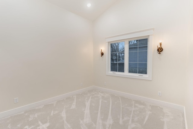 carpeted spare room featuring lofted ceiling