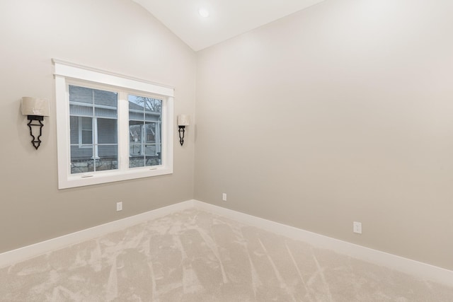 spare room featuring lofted ceiling and carpet flooring