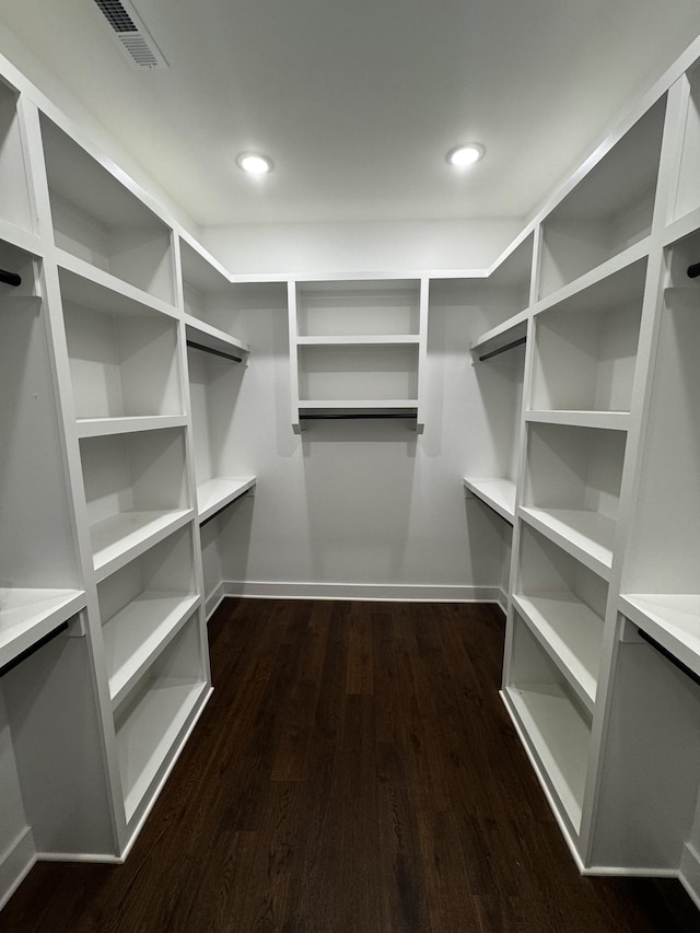 spacious closet with dark hardwood / wood-style flooring