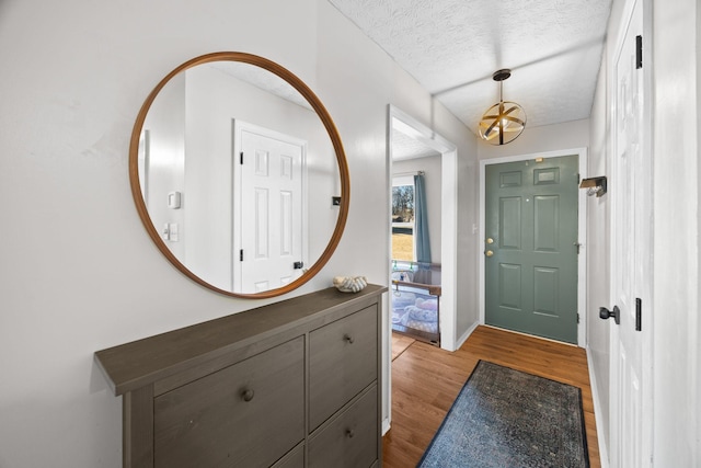 entrance foyer with a textured ceiling and light hardwood / wood-style flooring