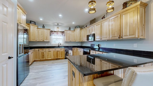 kitchen with a kitchen bar, light hardwood / wood-style flooring, hanging light fixtures, light brown cabinets, and stainless steel appliances