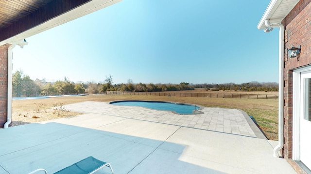 view of swimming pool featuring a rural view and a patio area