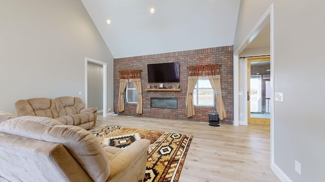 living room with a fireplace, light hardwood / wood-style flooring, and high vaulted ceiling