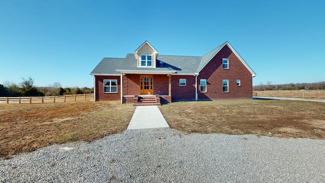 view of front of home with a front yard and a rural view