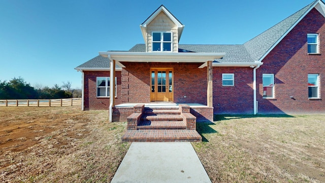 rear view of property with french doors and a lawn