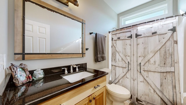 bathroom with toilet, vanity, a shower with curtain, and vaulted ceiling