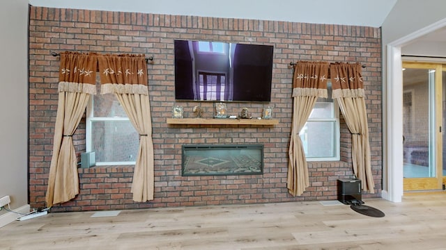 unfurnished living room featuring a large fireplace, lofted ceiling, and light hardwood / wood-style flooring