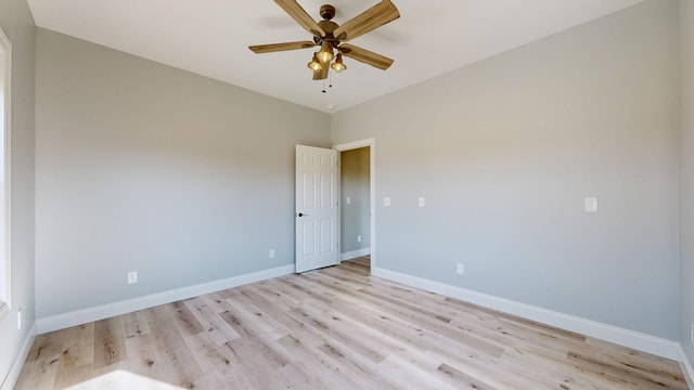 empty room with ceiling fan and light hardwood / wood-style flooring