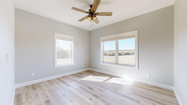 spare room featuring ceiling fan, a healthy amount of sunlight, and light hardwood / wood-style flooring