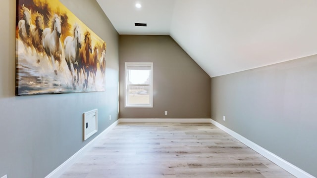 bonus room featuring vaulted ceiling and light wood-type flooring