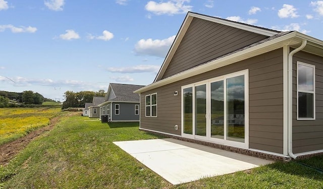 view of side of property featuring a yard and a patio