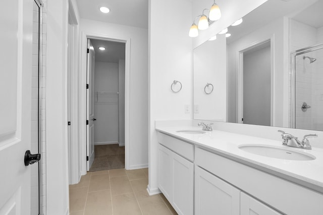 bathroom featuring a shower with shower door, vanity, and tile patterned flooring