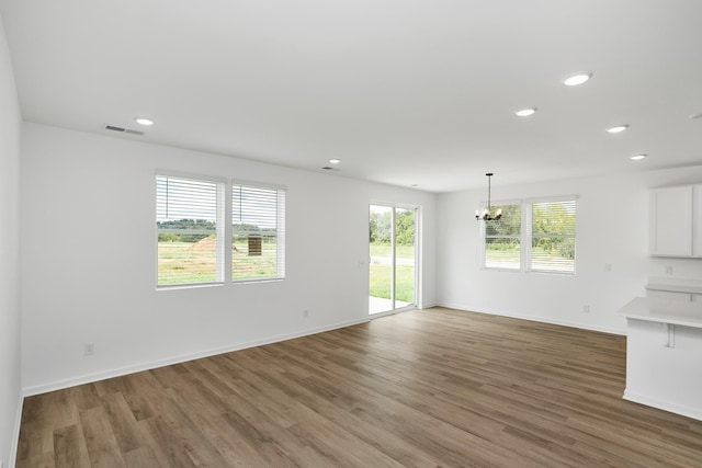 unfurnished living room featuring dark hardwood / wood-style floors and a notable chandelier