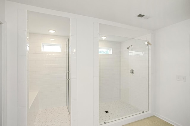 bathroom with tile patterned flooring and a shower with door