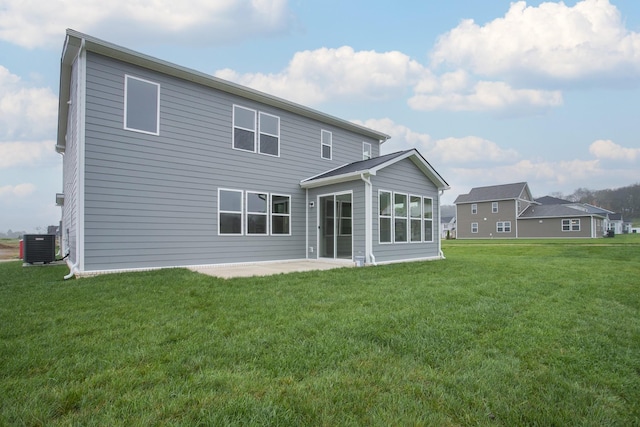 rear view of property featuring central AC unit, a yard, and a patio