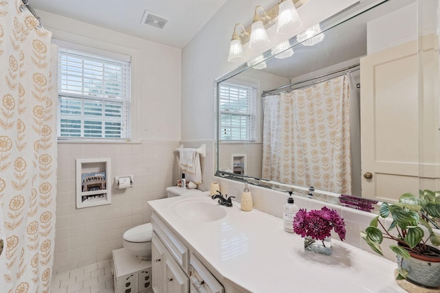 bathroom featuring tile walls, vanity, tile patterned floors, and toilet