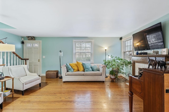 living room featuring a tiled fireplace and light hardwood / wood-style flooring