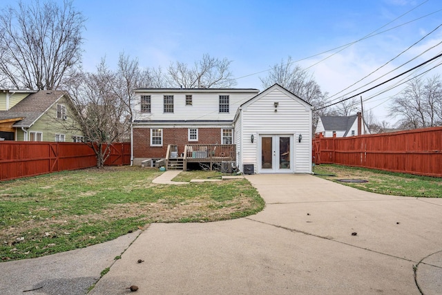 back of property featuring central AC unit, a lawn, a deck, and french doors