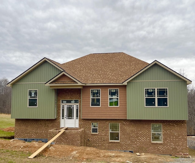 split foyer home with a shingled roof and brick siding