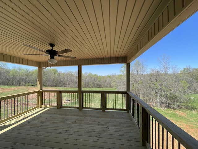 deck with ceiling fan and a forest view