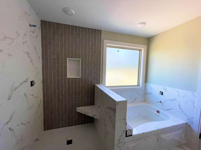 bathroom with a shower, tile walls, and a garden tub