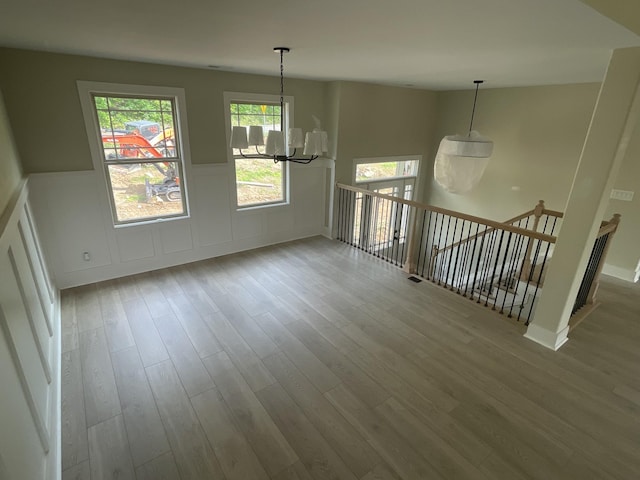975 Palmyra Rd, Clarksville, TN 37040 - spare room featuring a chandelier, wood finished floors, a wainscoted wall, and a decorative wall
