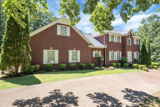 colonial home featuring a front lawn