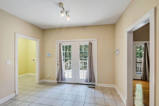 doorway to outside featuring light tile patterned floors and track lighting